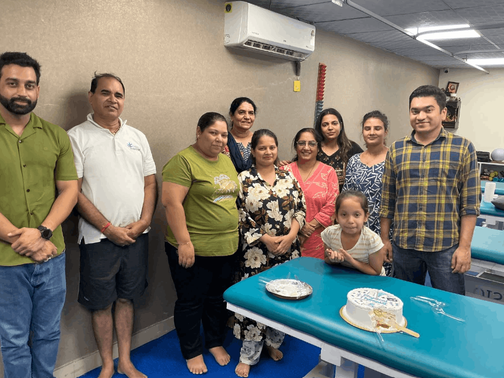 PHYSIOMOTION physiotherapy clinic team and patients celebrating a special occasion in Faridabad